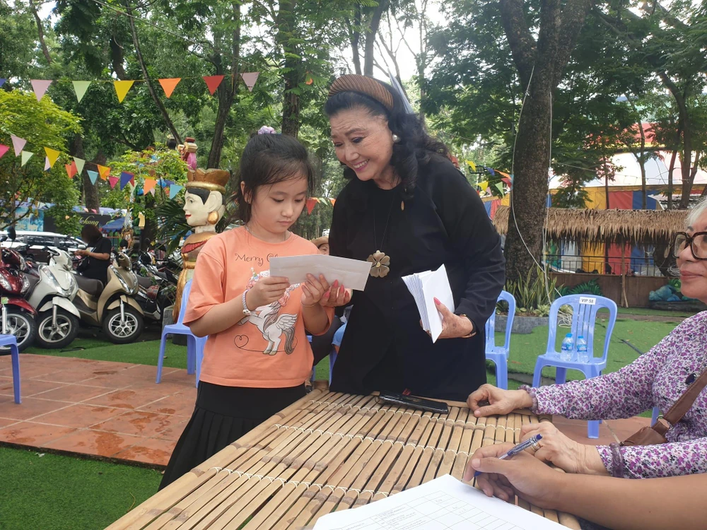 NSND Kim Cương trao tiền hỗ trợ cho các bé. Ảnh: VĂN HÀ.