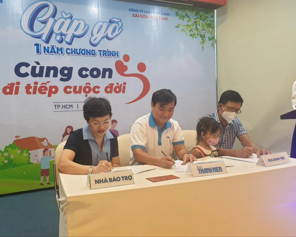 Bà Đặng Thị Kim Liên ký kết với ông Nguyễn Ngọc Toàn và phụ huynh thỏa thuận bảo trợ cho em Nguyễn Ngọc Hoàng Anh (TP. Thủ Đức). Ảnh: KHÁNH AN