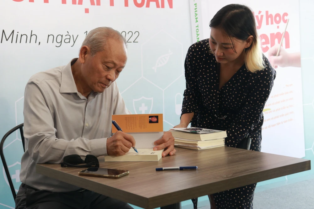 Tiến sĩ Phạm Toàn ký sách tặng bạn đọc.Ảnh: VÕ THƠ