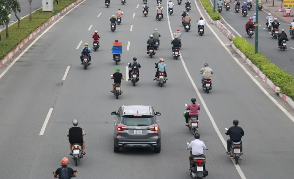 Một chiếc ô tô bị bao vây bởi xe máy. Một chiếc ô tô bị bao vây bởi xe máy.