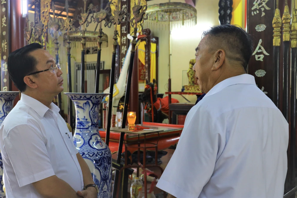 Ông Trần Thế Thuận trao đổi với Trưởng Ban quản lý Đình Tân Thới Nhất về lịch sử của đình. Ảnh: VÕ THƠ