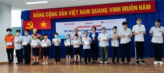Bà Nguyễn Thị Kiều Nhi, Phó Chủ tịch UBND quận Phú Nhuận và ông Trần Phước Sang, Phó trưởng VPĐD Agribank khu vực miền Nam trao học bổng cho các em học sinh.