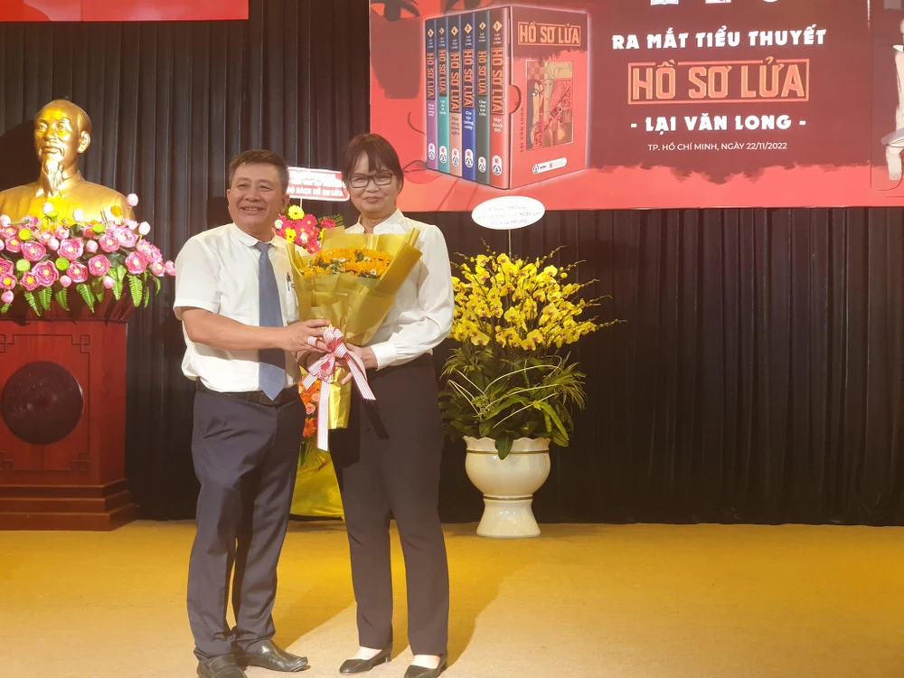 Nhà văn Bích Ngân, Chủ tịch Hội Nhà văn TP.HCM tặng hoa chúc mừng nhà văn Lại Văn Long. Ảnh: HÀ NGUYỄN