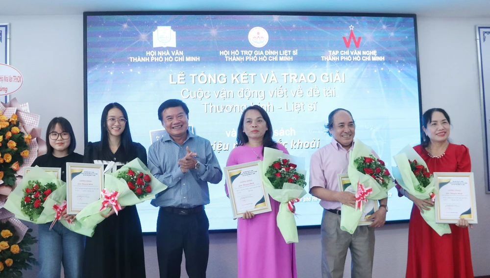 Nhà văn Bùi Anh Tấn trao giải khuyến khích cho các tác giả. Ảnh: HÀ NGUYỄN