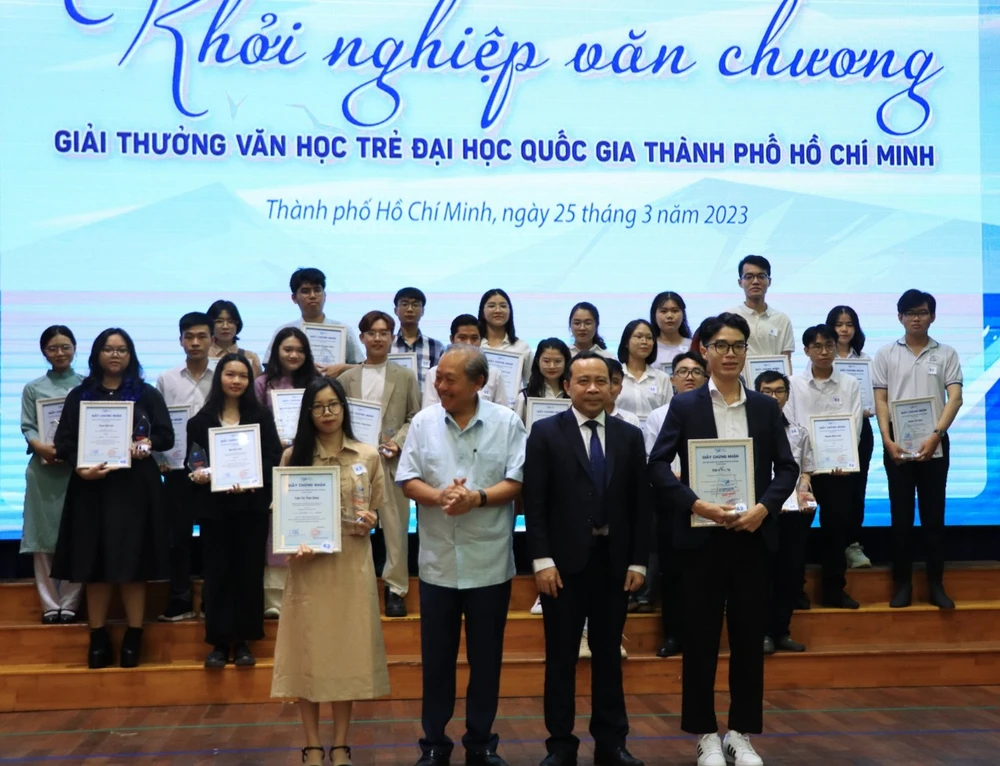 Ông Trương Hòa Bình (nguyên Phó thủ tướng Chính phủ) và Giám đốc ĐHQG TP.HCM Vũ Hải Quân trao giải nhất thể loại tản văn và thơ cho tác giả Trần Thị Thùy Dung (trái) và Trần Văn Thiên (phải). Ảnh: HÀ NGUYỄN