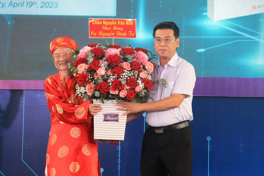 Ông Nguyễn Văn Dũng, Phó Chủ tịch HĐND TP.HCM tặng hoa của Bí thư Thành uỷ Nguyễn Văn Nên đến Nhà nghiên cứu Nguyễn Đình Tư.