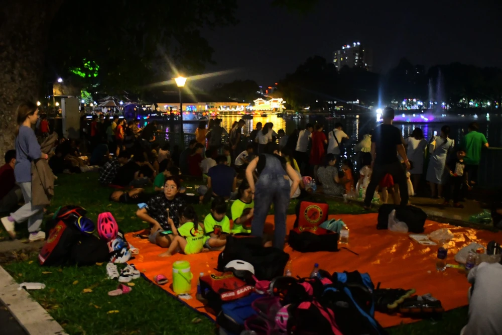 Người dân ngồi kín khu vực bắn pháo hoa tại Đầm Sen. Ảnh: H.N