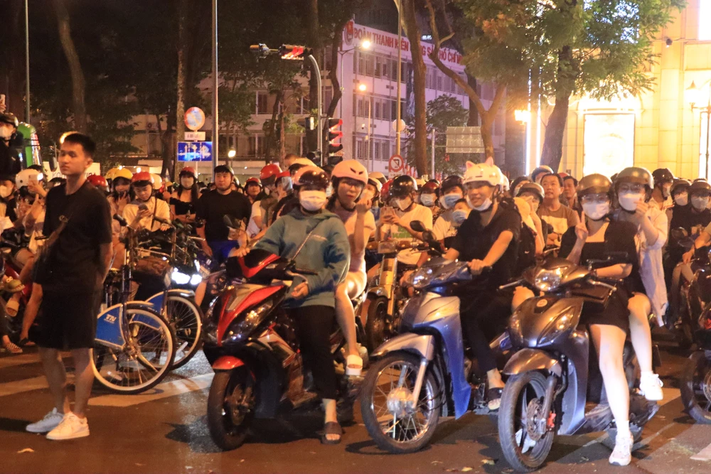 Thay vì ra bờ sông Sài Gòn hay Bến Bạch Đằng, nhiều người dân lại chọn đứng tại đường Lê Duẩn để ngắm pháo hoa từ xa. Ảnh: H.N