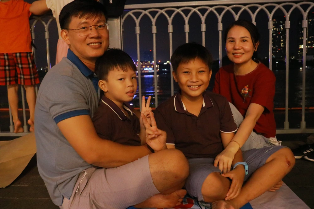 Đến đợi xem pháo hoa từ sớm, gia đình anh Võ Công Thơ (ngụ Thủ Đức) cho biết: "Nhân dịp lễ 30-4 tôi muốn đưa vợ và hai con ra đây để thư giãn. Trước tình hình dịch bệnh đang gia tăng trở lại gia đình chủ động phòng chống và cẩn thận trong giao tiếp khi ra nơi đông người". Ảnh: VÕ THƠ