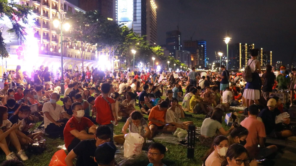 Người dân ngồi kín hai bên bờ để chờ theo dõi bắn pháo hoa. Ảnh: VÕ THƠ