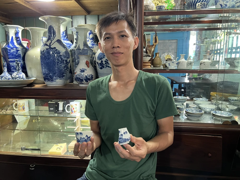 Anh Nguyễn Khắc Duy cùng với những cổ vật cần được phục chế. Ảnh: QUỐC HƯƠNG