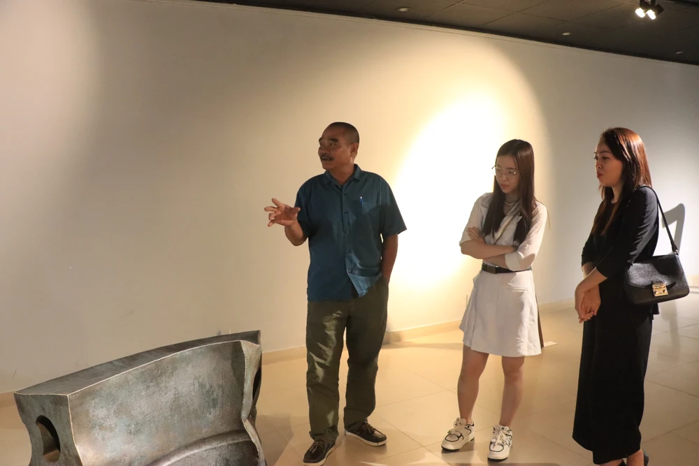 Nhà điêu khắc Hoàng Tường Minh chia sẻ về tác phẩm với người xem. Ảnh: H.N