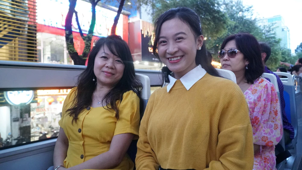 Chị Lê Mai Hân ( bên trái, người gốc Việt) trong thời gian sinh sống tại Mỹ chị đã có cơ hội nhiều lần nhìn thấy xe buýt 2 tầng tuy nhiên lần này có dịp về Việt Nam chơi chị mới trải nghiệm du lịch bằng loại hình này. Chị bày tỏ: “ Thời tiết khá mát mẻ và thuận lợi cho việc ngồi trên xe ngắm cảnh. Tôi được dạo chơi qua nhiều cung đường, tham quan nhiều địa điểm nổi tiếng để có thêm trải nghiệm và kiến thức.”