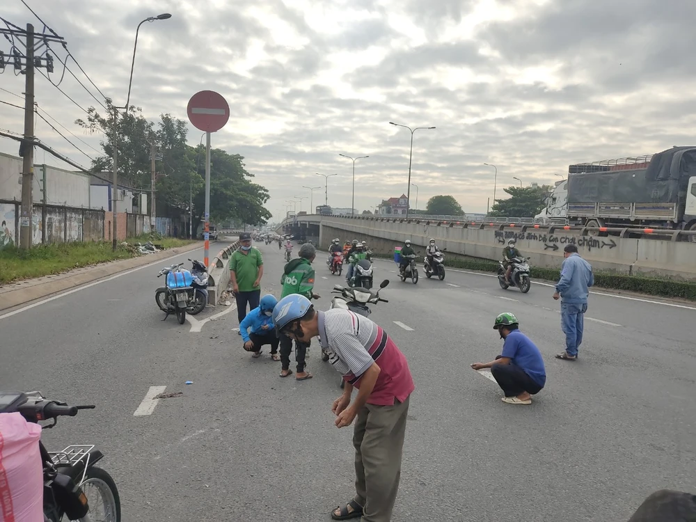 Người dân dừng xe xuống đường nhặt đinh tặc giờ cao điểm ở TP Thủ Đức