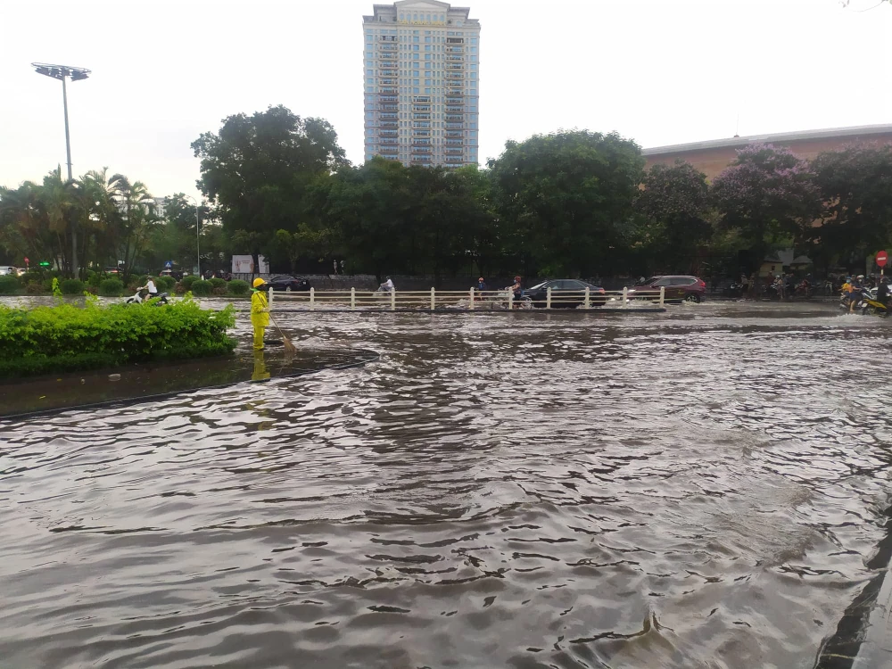 Ngã tư Nguyễn Văn Huyên - Nguyễn Khánh Toàn nước ngập sâu, nhiều xe chết máy giữa đường, người dân đi lại rất khó khăn. Ảnh: MINH TRÚC