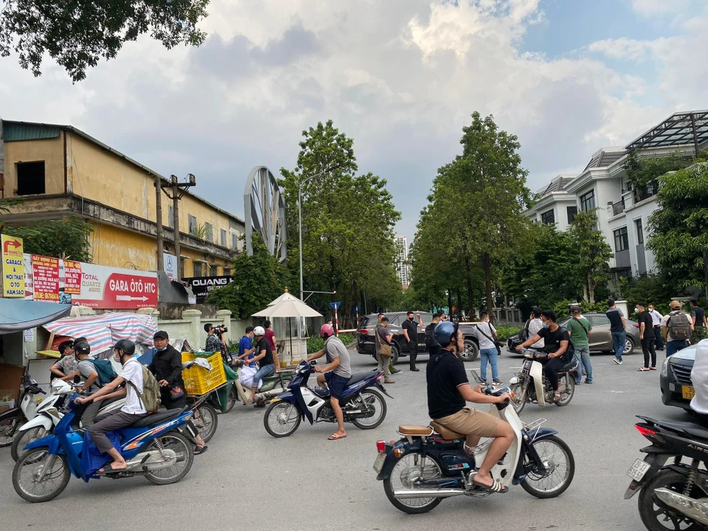 Nhiều người dân tò mò đứng lại xem diễn tiến vụ việc ở khu vực đi vào nhà ông Chu Ngọc Anh: Ảnh: NHƯ LOAN