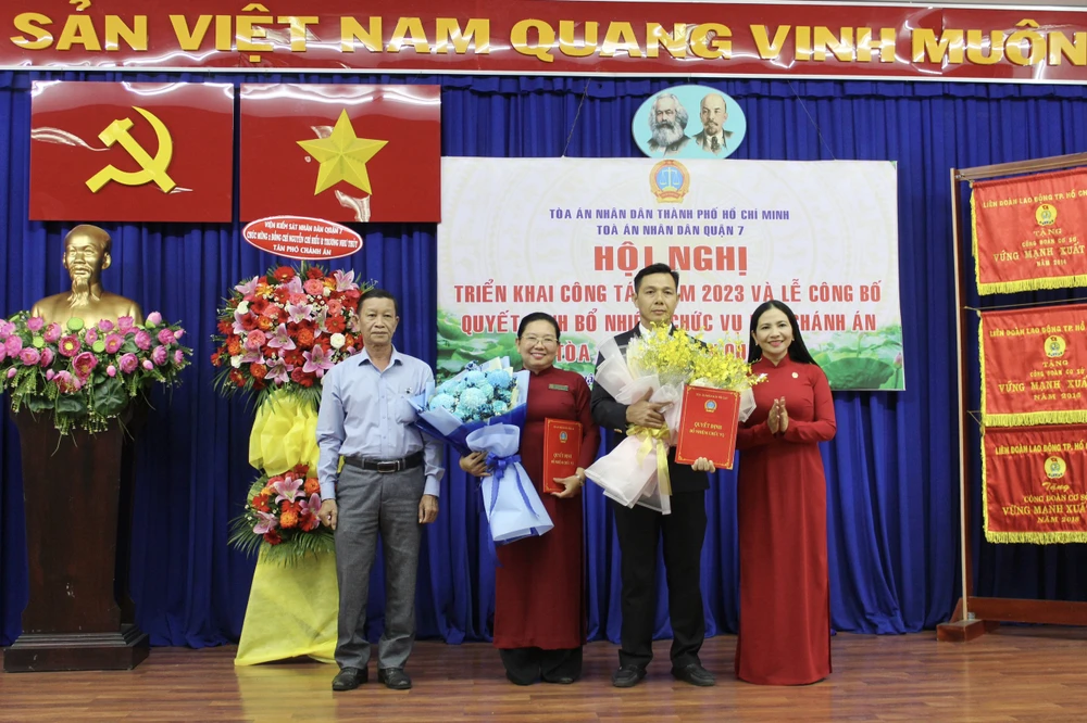 Ông Nguyễn Chí Hiếu và bà Trương Như Thủy (cầm hoa) được bổ nhiệm giữ chức vụ phó chánh án TAND quận 7. Ảnh: BMC