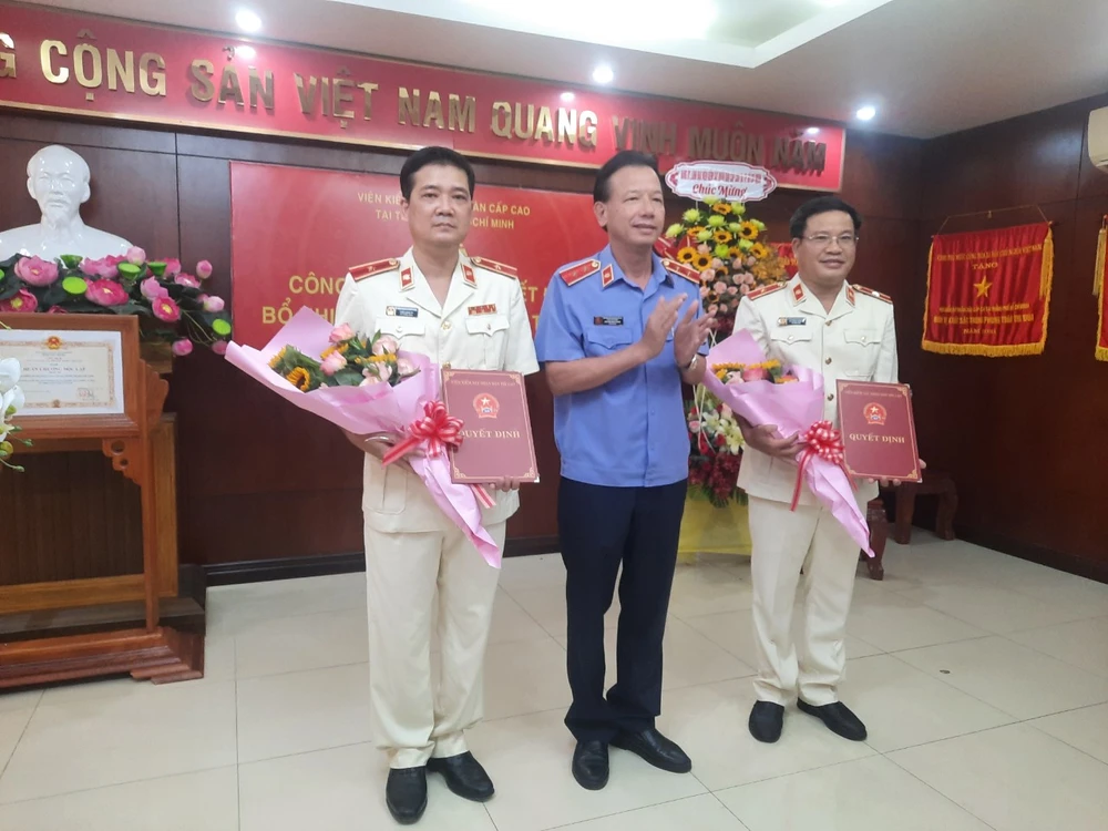 Ông Nguyễn Đình Trung, Viện trưởng VKSND Cấp cao tại TP.HCM trao quyết định cho hai tân kiểm sát viên cao cấp. Ảnh: MINH CHUNG