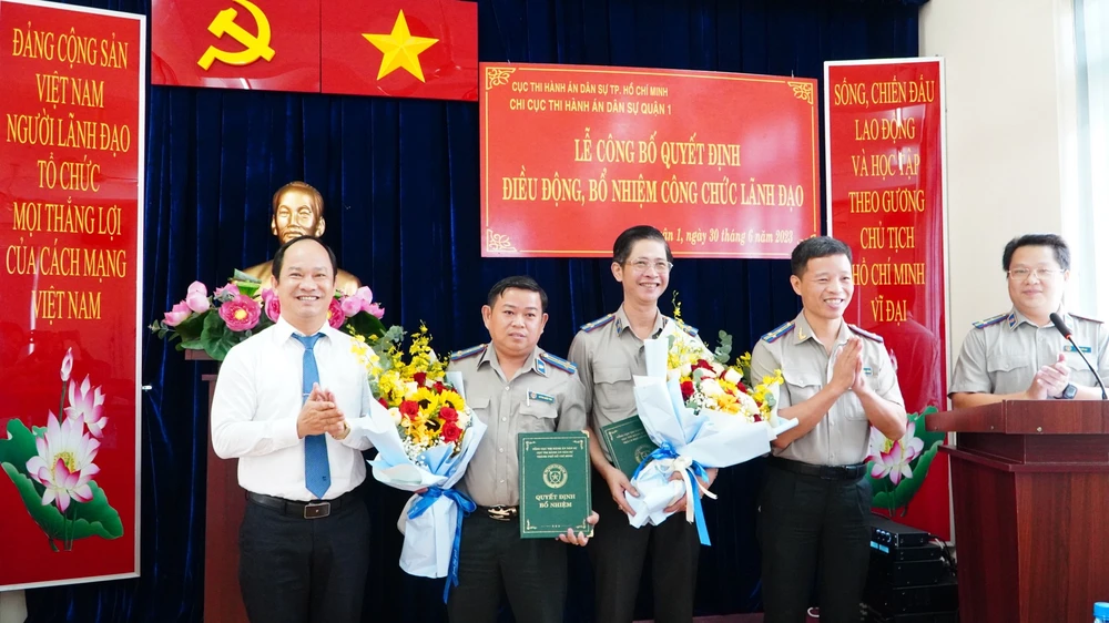 Ông Trần Quốc Khánh (bên phải, cầm hoa) và ông Huỳnh Quốc Vinh (bên trái, cầm hoa) tại buổi lễ. Ảnh: Cục THADS TP.HCM