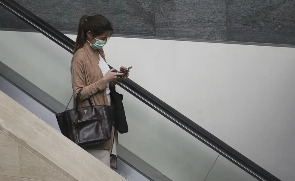 mot-phu-nu-deo-khau-trang-va-su-dung-dien-thoai