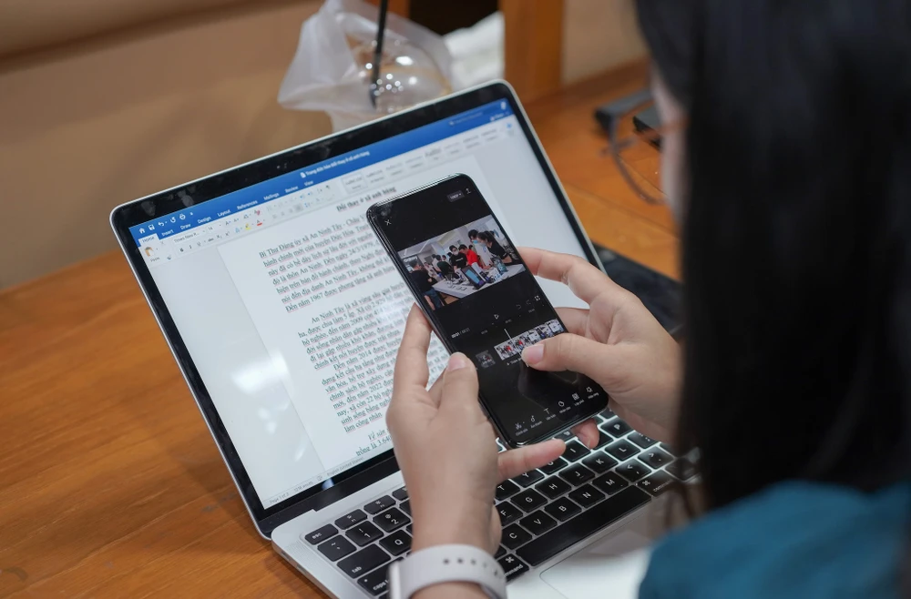 Điện thoại thông minh giúp PV có thể tác nghiệp mọi lúc mọi nơi, từ viết tin bài cho đến quay dựng video. Ảnh: TIỂU MINH