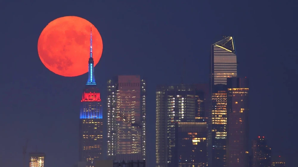 Siêu trăng đi qua phía sau Tòa nhà Empire State vào ngày 23-7-2021. Ảnh: Gary Hershorn/Getty Images