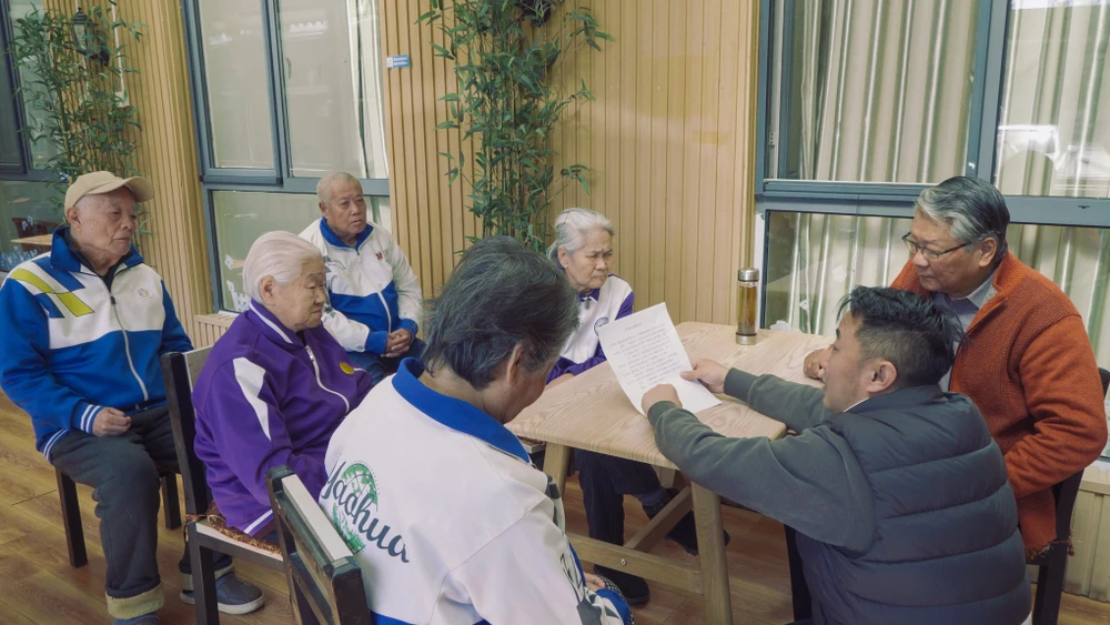 Feng Yan (áo xám) thảo luận về kịch bản với cư dân viện dưỡng lão Jingya. Ảnh: Ding Rui/Sixth Tone