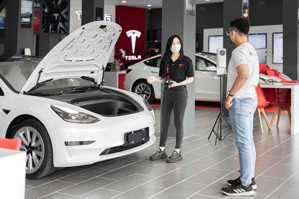 Tin công nghệ 14-8: Nhân viên Tesla giới thiệu các mẫu xe cho khách hàng.