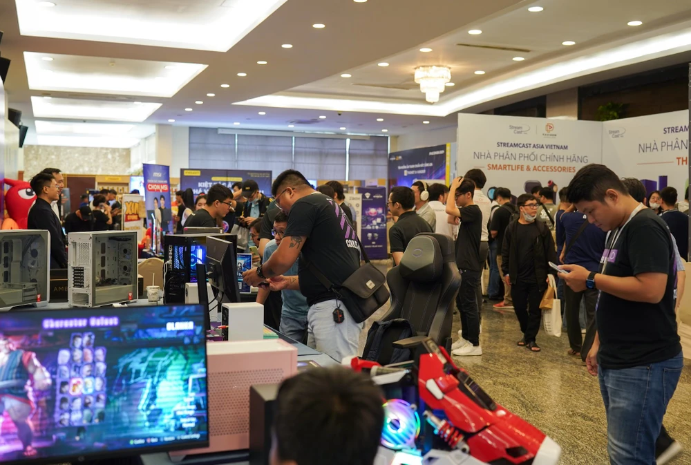 Khách tham quan trải nghiệm các thiết bị âm thanh, máy tính. Ảnh: TIỂU MINH