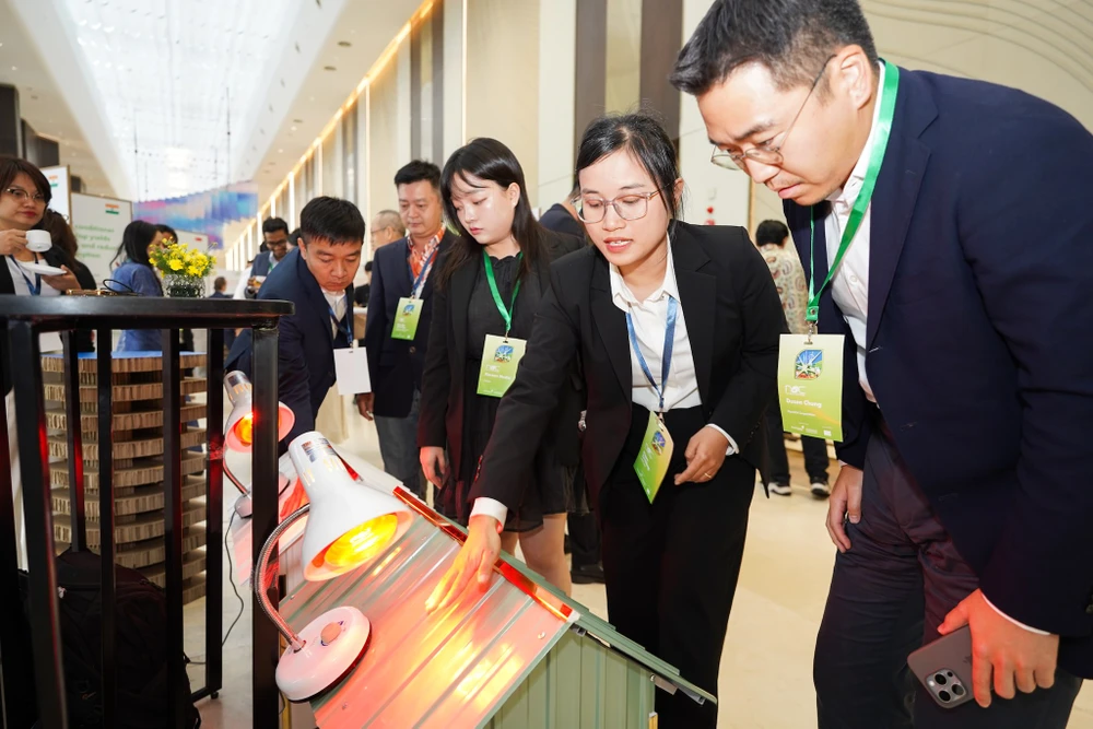 Người dùng đang trải nghiệm công nghệ sơn chống nóng, giúp mái nhà mát hơn. Ảnh: TIỂU MINH