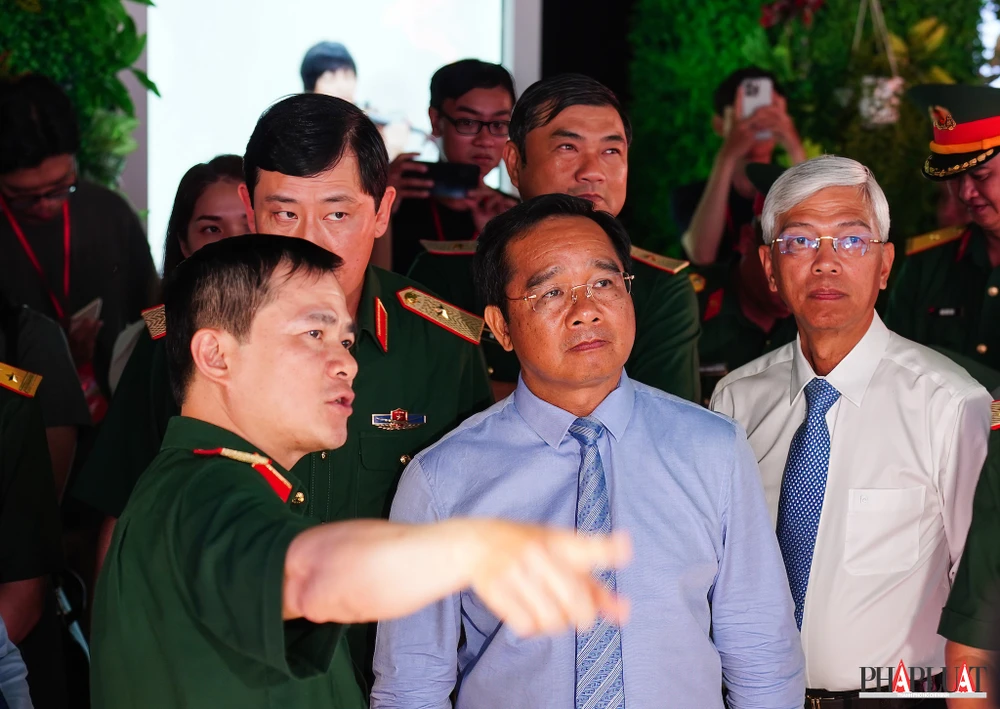 Chủ tịch UBND TP.HCM Nguyễn Văn Được (giữa) và các đại biểu đi tham quan các gian hàng, trưng bày sản phẩm công nghệ cao của Viettel. Ảnh: TIỂU MINH