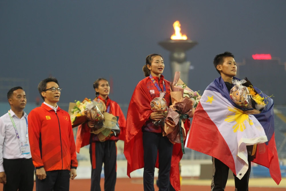 Phó thủ tướng - Trưởng ban chỉ đạo SEA Games 31 Vũ Đức Đam trao HCV 5.000 m cho nhà vô địch Nguyễn Thị Oanh. ẢNH: QUÝ LƯỢNG