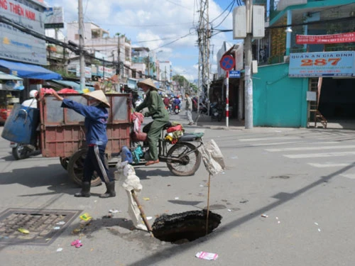 Xe chở rác sụp “hố tử thần” ảnh 1