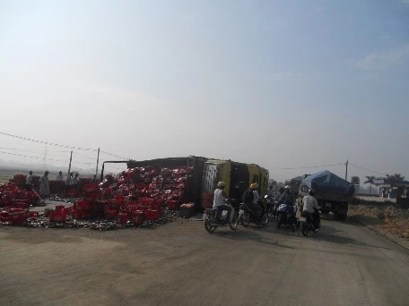 Container lật nhào, hàng trăm thùng bia "lấp" kín đường ảnh 1