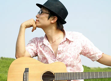 Hình ảnh ca sĩ Hải Triệu bên đàn guitar quen thuộc ở Nhật. Ảnh: L.M.