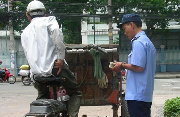 Bảo vệ thu phí khi tài xế rời khỏi 42-44 Võ Thị Sáu. (Ảnh chụp sáng 7-8). Ảnh: VÕ BÁ