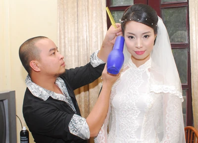 Chuyên gia trang điểm David Minh Đức giúp á hậu Vân Anh làm tóc trong ngày cưới.