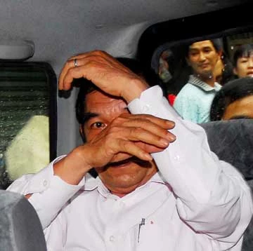 Ông Sỹ che mặt trước các ống kính nhà báo. Ảnh: HTD