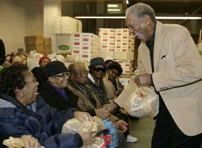 Morgan Freeman (bìa phải) trong một buổi cứu tế dành cho người cao tuổi tại Washington (Mỹ) - Ảnh: Reuters