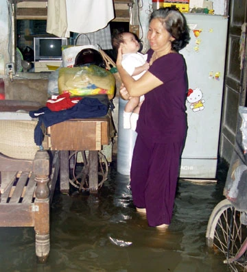 Bà Nguyễn Thị Thái (phường 19, quận 8) dỗ cháu khi nước lên. Ảnh: HTD