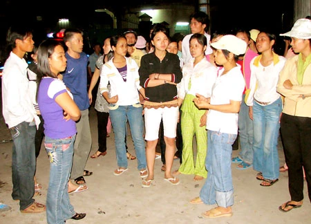 Công nhân Công ty TNHH Quang Sung Vina tụ tập trước cổng công ty trong đêm để canh giữ máy móc sau khi chủ doanh nghiệp bỏ trốn vào tháng 11-2008. Ảnh: MAI HƯƠNG