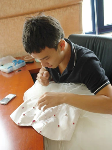 Nhà thiết kế Huy Võ đính đá lên chiếc váy.