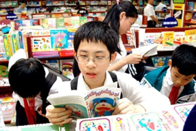 Một học sinh mải mê đọc truyện trong hiệu sách sau giờ tan học. Ảnh: Hoàng Hà.