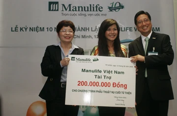 BS Lâm Hoài Phương, Giám đốc Bệnh viện Răng Hàm Mặt trung ương nhận tấm séc tượng trưng từ tổng giám đốc Manulife Việt Nam và ca sĩ Hải Yến (giữa).