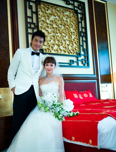 Đôi uyên ương chụp ảnh bên giường cưới.