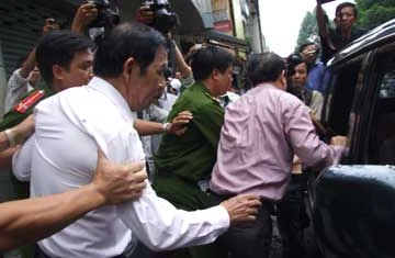 Ông Sỹ được áp giải từ nhà ra xe về trại giam. Ảnh: TRUNG DUNG