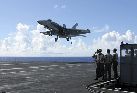 Một chiếc phi cơ FA-18 Hornet hạ cánh xuống boong của tàu sân bay USS George Washington tại tây Thái Bình Dương. George Washington là một căn cứ không quân nổi trên biển. Đây giống như một thành phố với khoảng 5.000 người, 67 phi cơ và 1,8 triệu kilogram bom. Ảnh: AP.