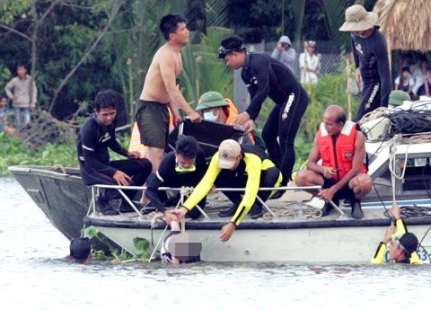 Thi thể một bé gái được đưa lên khỏi mặt nước. Ảnh: An Nhơn