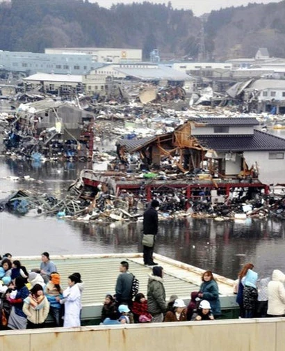 Người dân ở khu vực cảng Kesennuma nhìn đống đổ nát từ ngôi nhà của mình sau thảm họa.