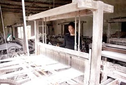 Chị Nguyễn Thị Cửu (thôn Châu Hiệp, thị trấn Nam Phước, huyện Duy Xuyên) buồn rầu bên khung cửi. Ảnh: NG.KHÔI